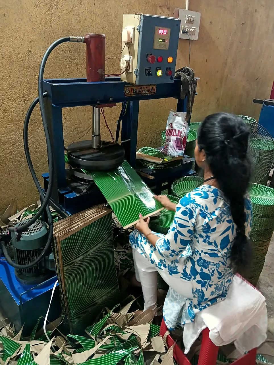 Leaf-print plates being pressed in the Omkara Udyog unit
